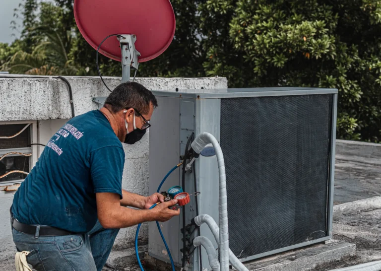 HVAC technician inspecting a residential air conditioning condenser unit.