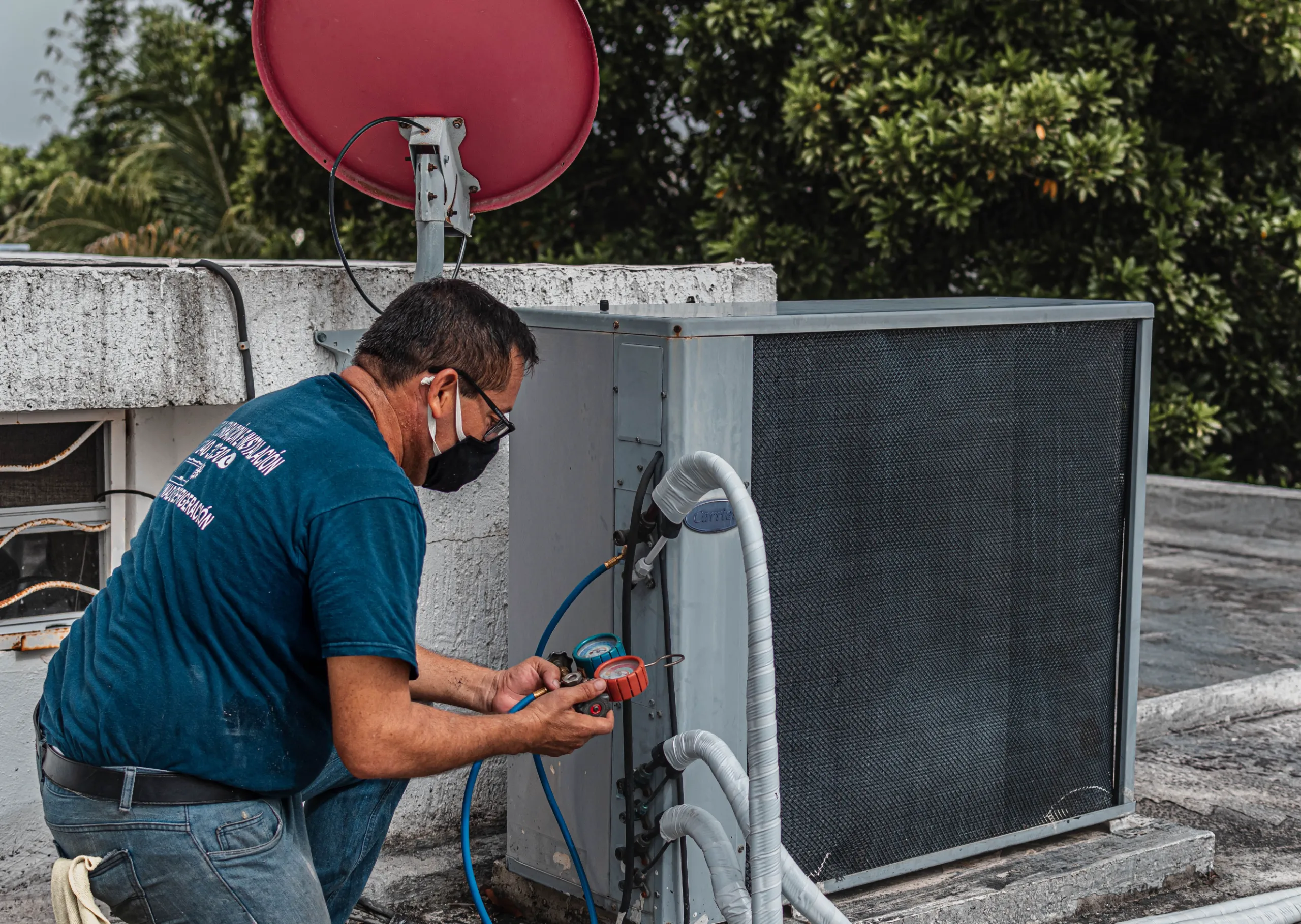 HVAC technician inspecting a residential air conditioning condenser unit.